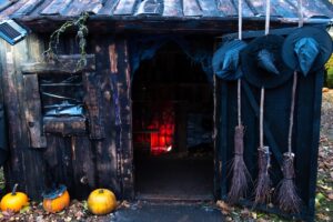 A haunted witch's house decorated with pumpkins, hats and brooms