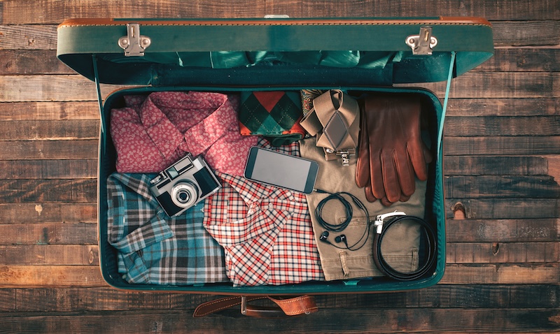 Vintage suitcase packed with fall coloured/style clothes. Packing for fall trip.