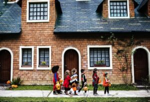 group of six children trick or treating before sunset