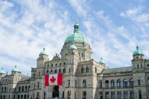 parliament buildings and Canadian flag on a sunny day - downtown Victoria, BC