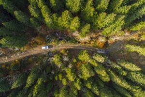 aerial photo of a 4x4 on a trail through the forest