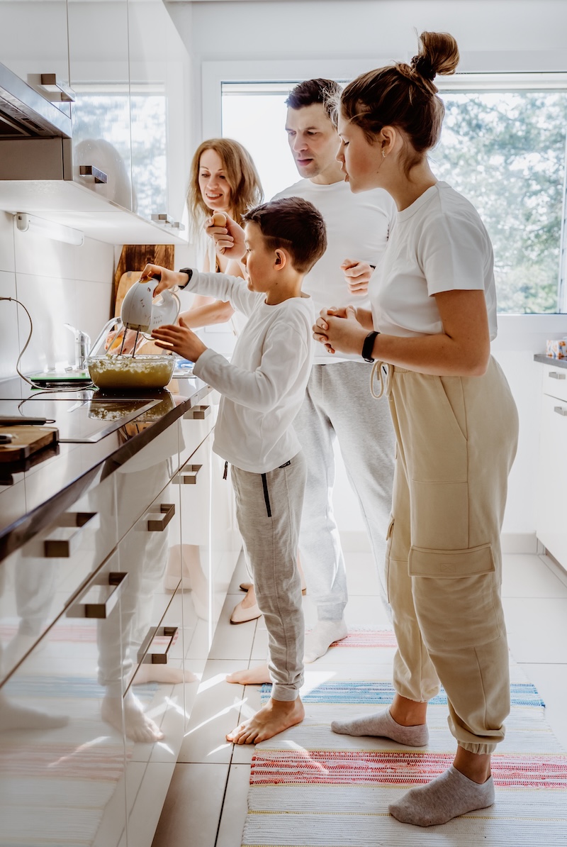 Family in a bright home together, baking in the kitchen