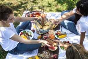 Summer picnic with friends in nature with food and drinks . The concept of personal time and summer vacation. Friendly communication and common interests.
