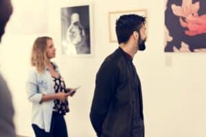 People looking at frames in exhibition - art gallery