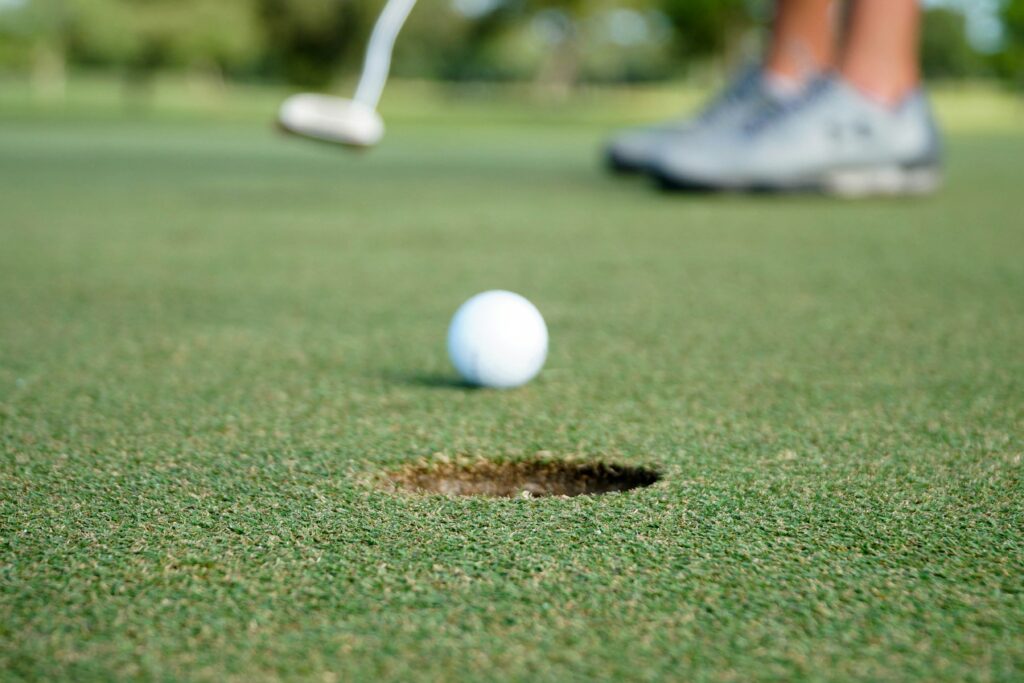 golfer putting - golf ball in foreground golfer in background